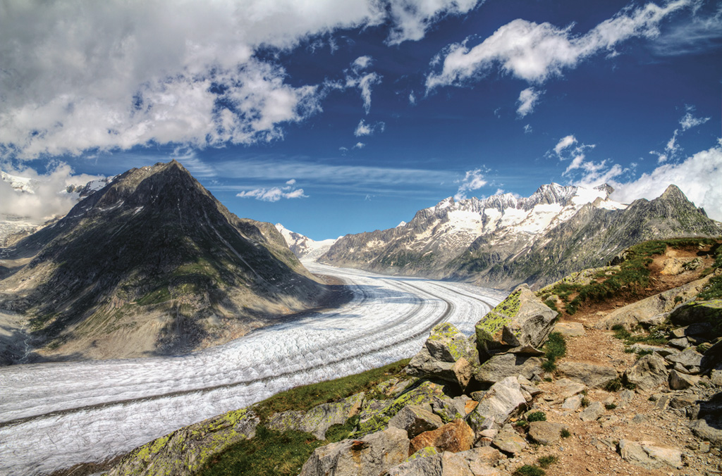 Beautiful panorama of the breathtaking Aletsch glacier as seen from the Bettmer alp in switserland, on a sunny day with clouds in summer.